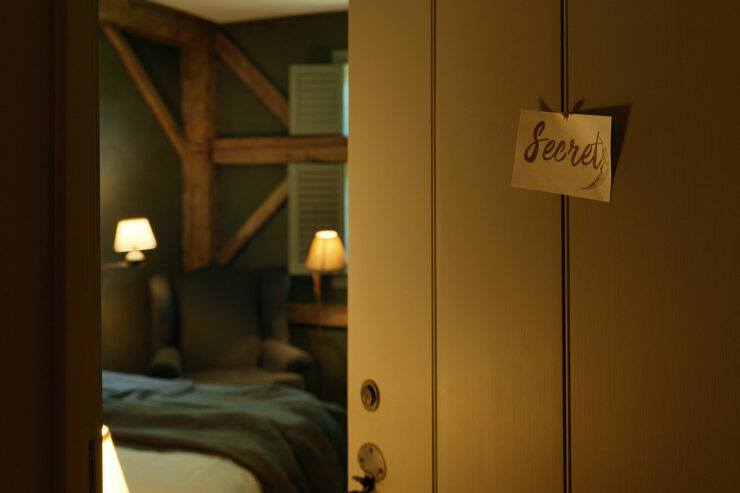 a partially open door featuring a note marked "secret"