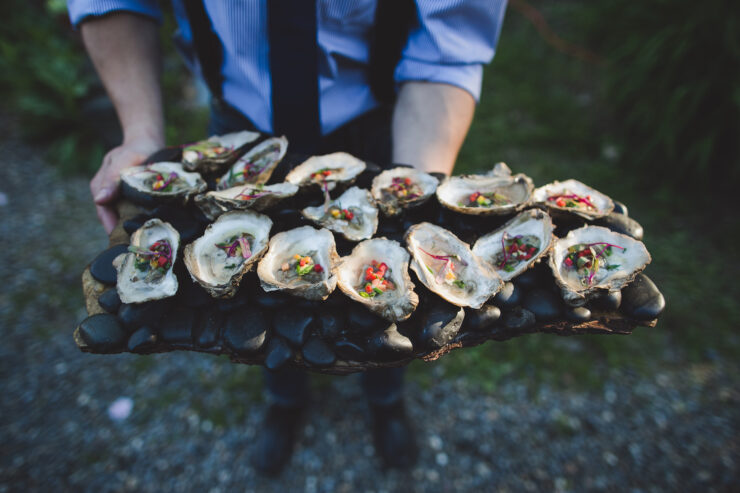 oyster appetizers displayed on a charred piece of wood
