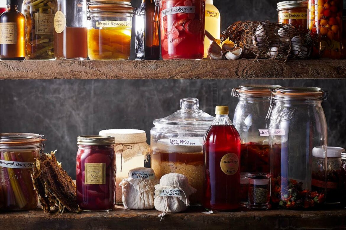 wooden shelves filled with jars of fruit and vinegar